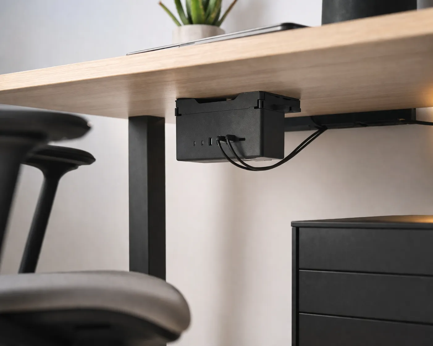 Praktisch ladeblok onder een bureau, netjes en modern voor een thuiswerkplek.